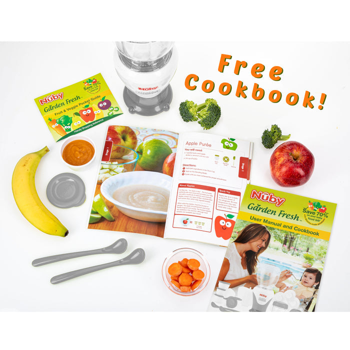 Flat lay of the Mighty Blender 22-Piece Baby Food System with two gray spoons, a bowl of sliced carrots, banana, apple, broccoli, and an open cookbook. "Free Cookbook!" appears at the top right. Nuby Garden Fresh branding highlights homemade baby food essentials.