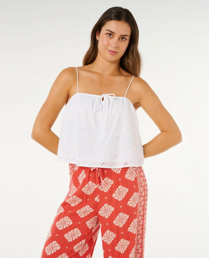 Woman wearing a white top and red patterned pants on a white background