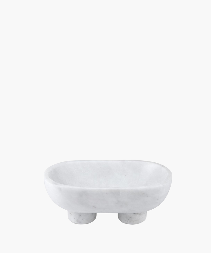 White marble footed bowl with a smooth, oval shape. It has a minimalist design and two sturdy round legs, conveying elegance and simplicity. | Wildwood Home Co.